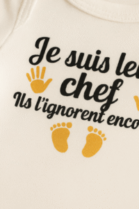 Zoom sur body bébé humoristique "Je suis leur chef, ils l’ignorent encore" coton premium Airlume hypoallergénique, impression durable