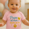 Bébé souriant en body rose “Papa et moi = équipe de feu” — body Ancabebe en coton doux, scène lumineuse.