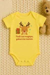 Body bébé Noël jaune avec renne et message “Noël c’est magique grâce à toi maman” posé sur plaid, ambiance festive